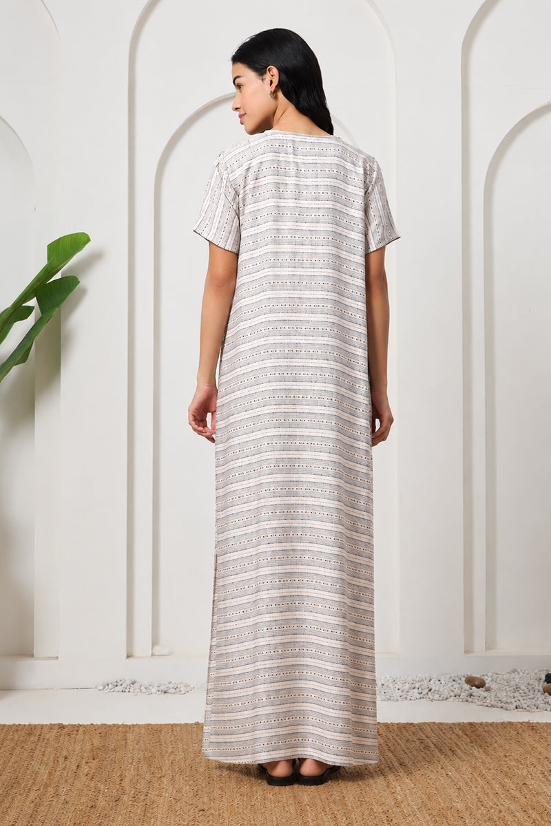 Back view of a woman in a beige striped nightgown