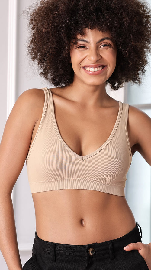 Model wearing beige ribbed V-neck wireless bra, front view