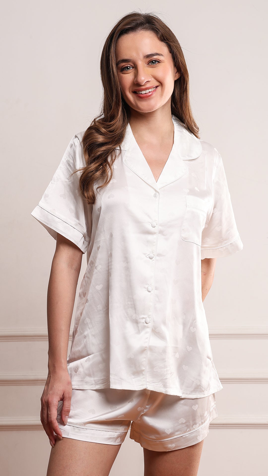 Woman wearing ivory satin pajama shirt with heart jacquard pattern