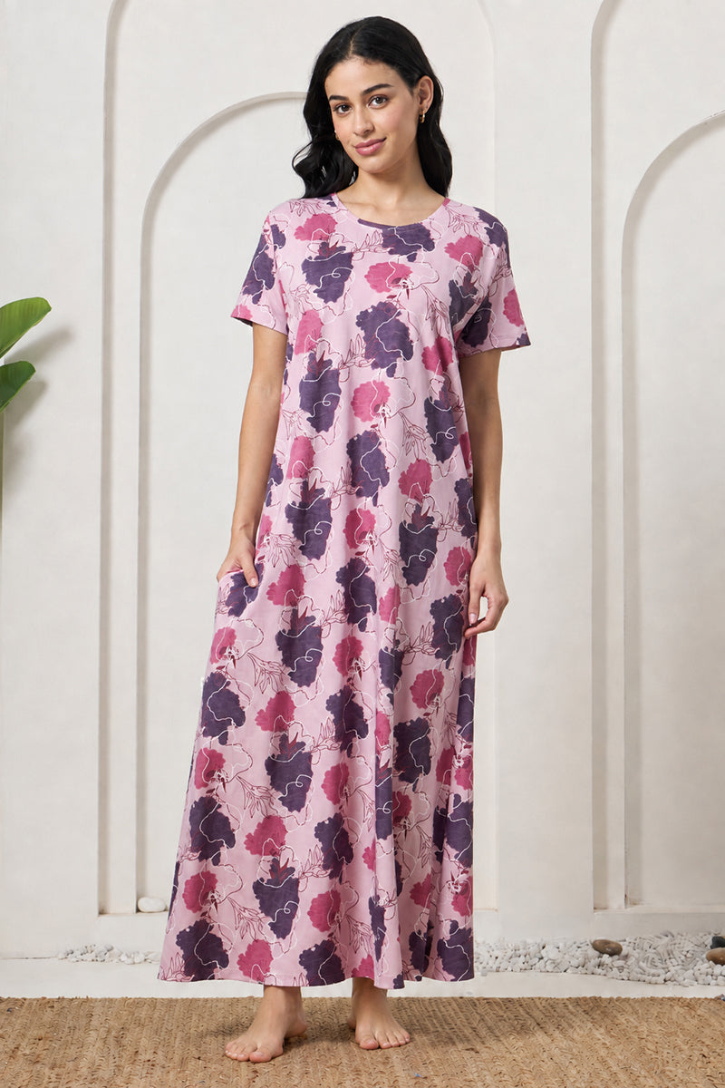 Woman standing in a pink and purple floral print maxi nightdress