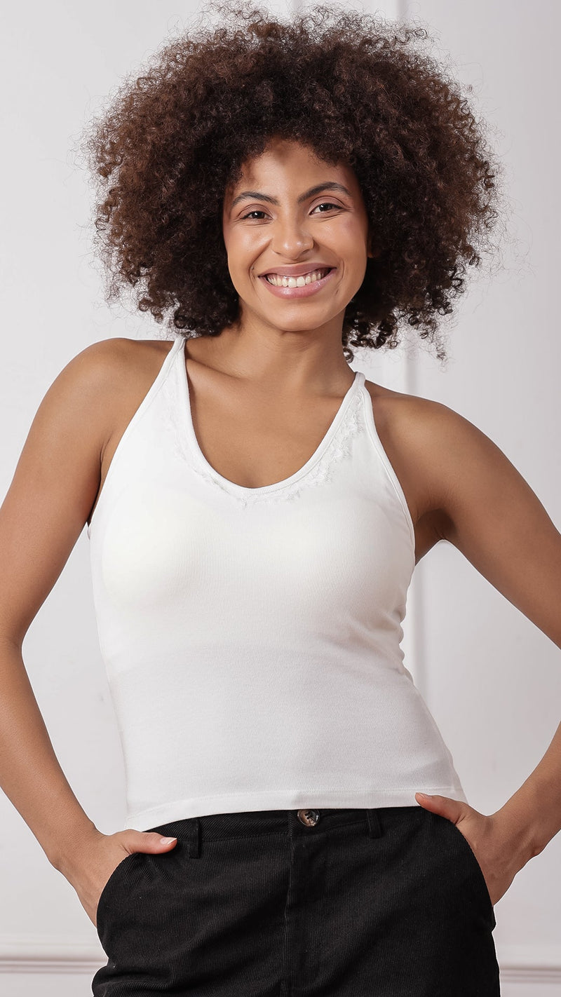 White lace-trim racerback tank top worn with black pants, front view
