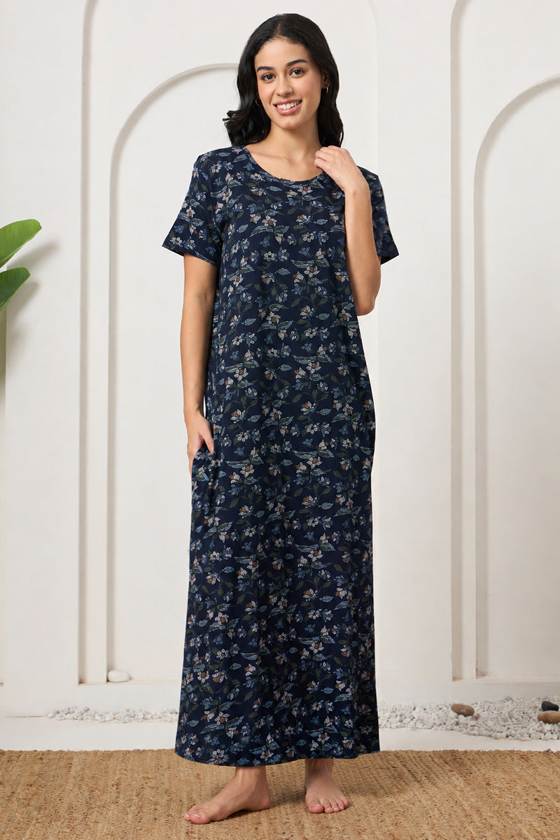 Woman standing in a navy floral print maxi nightdress