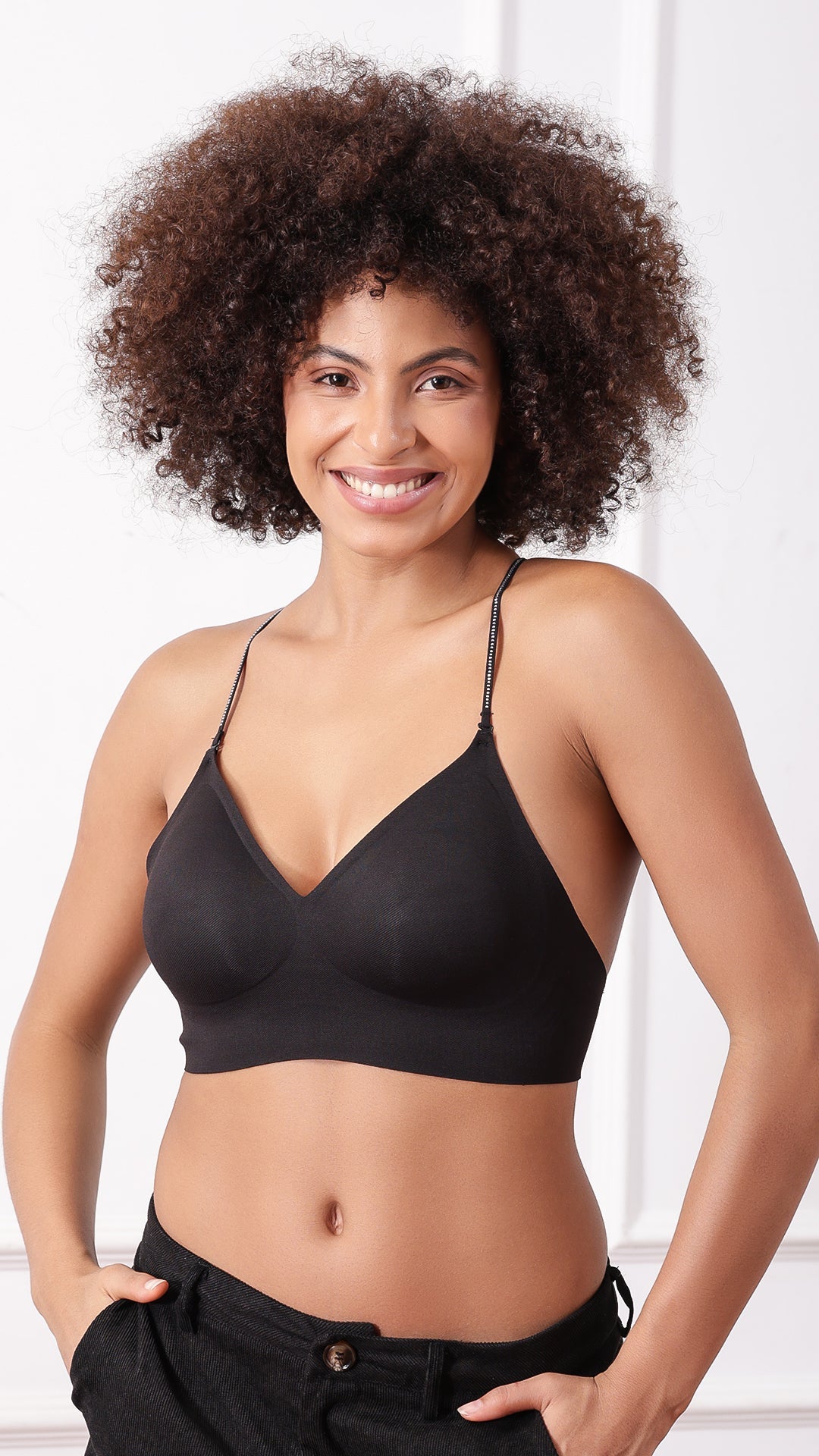 Woman wearing black V-neck bralette with criss-cross straps, front view