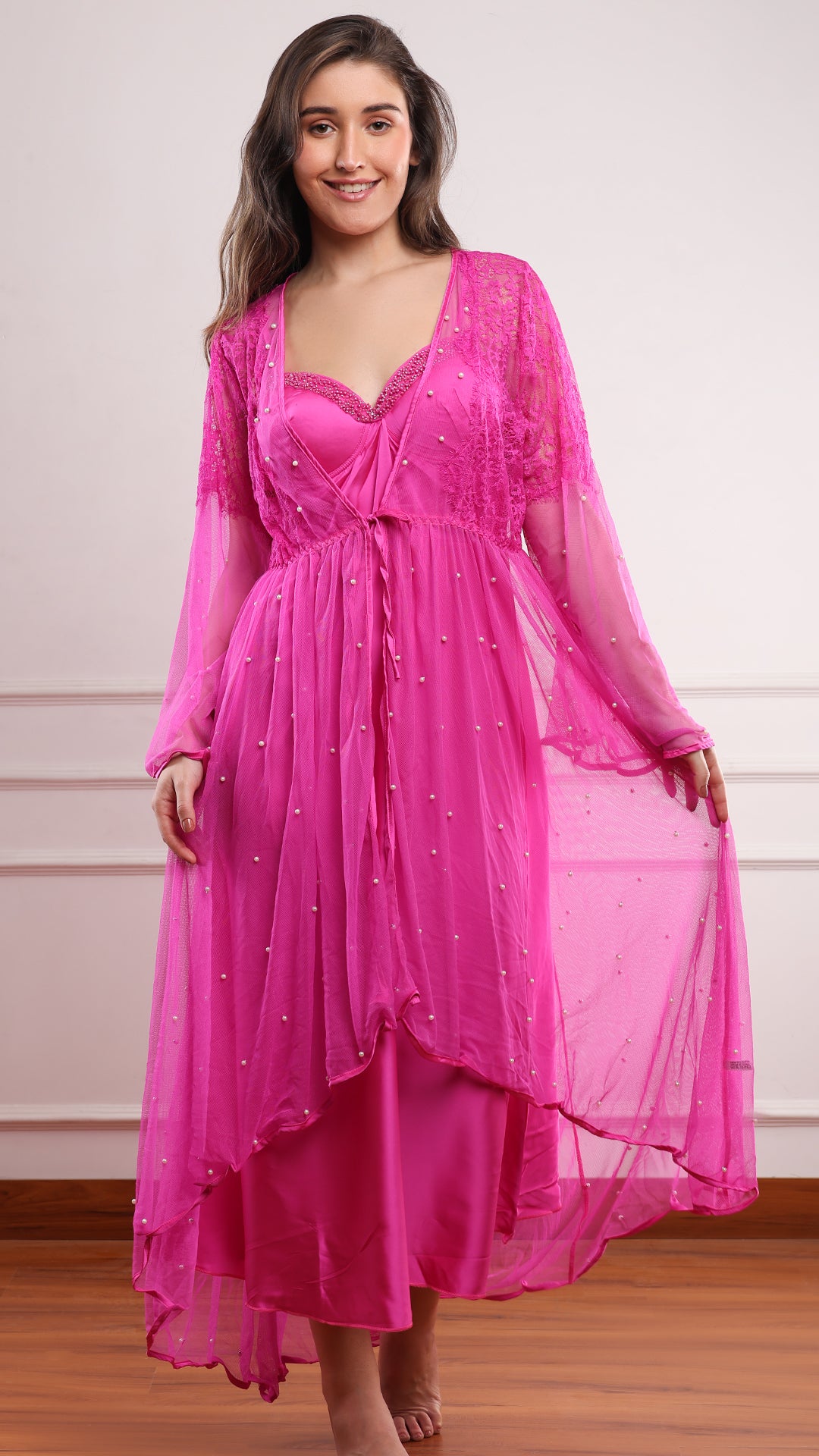 Woman wearing fuchsia pink satin nighty with pearl-beaded sheer robe and lace bell sleeves, full front view smiling