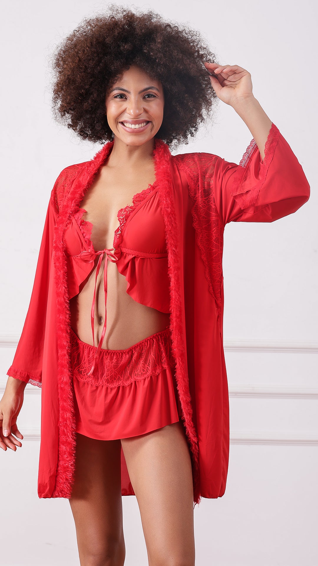 Woman wearing a red lace-trimmed lingerie set and marabou-trim robe, front view