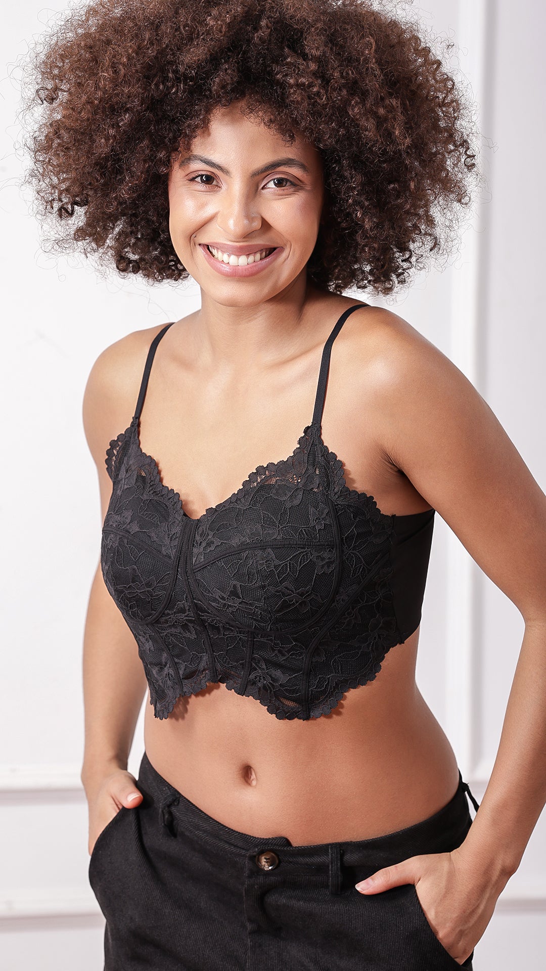 Model posing in black lace corset bra, front view