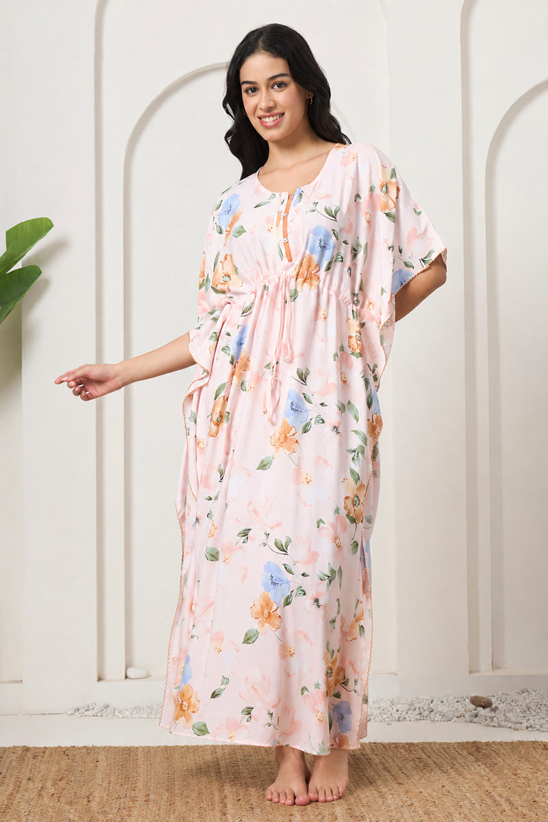 Woman smiling in a pink floral print kaftan