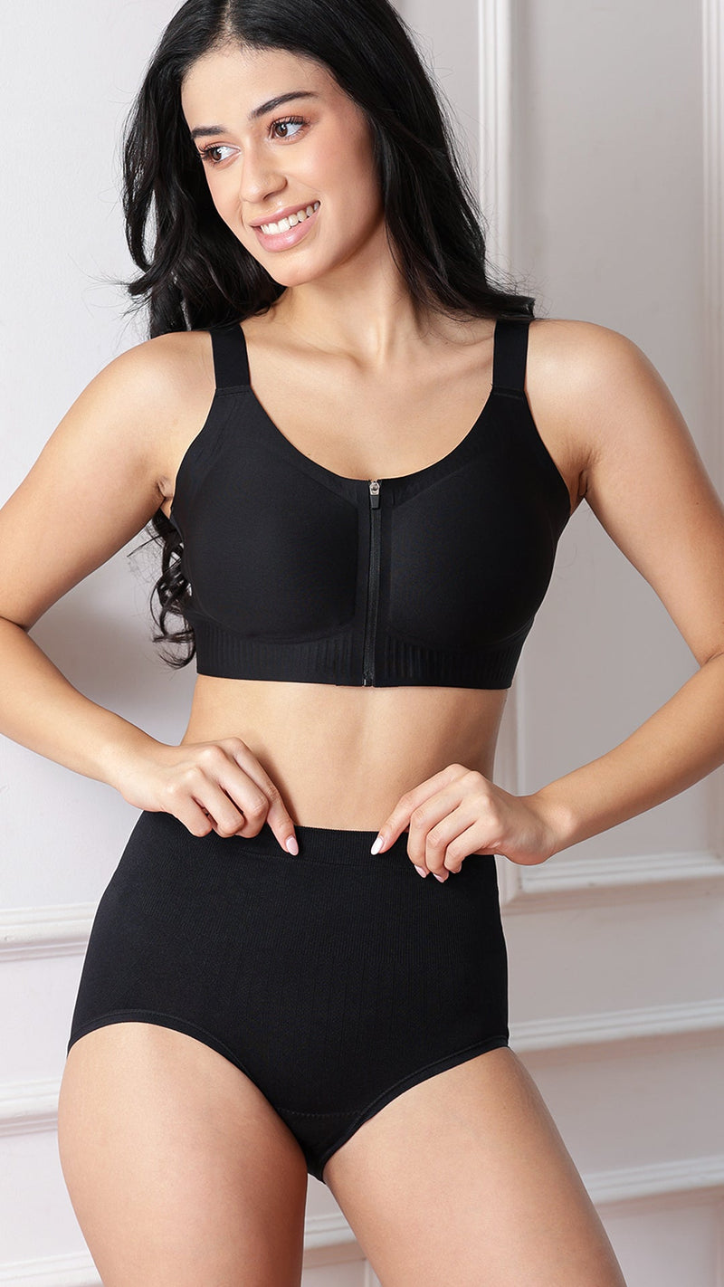 Model wearing black front-zip sports bra and high-waist shaper brief, front view