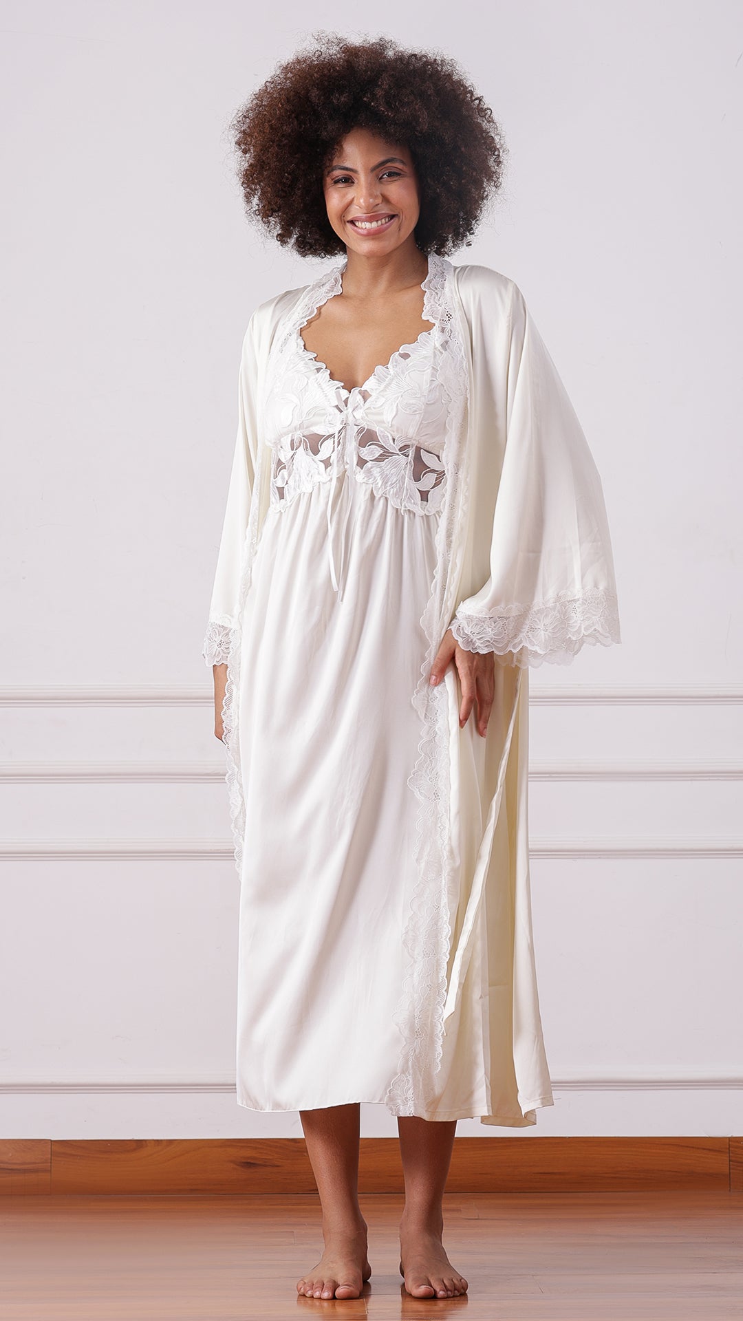 Woman wearing an ivory satin nightgown with matching lace-trimmed robe, full length