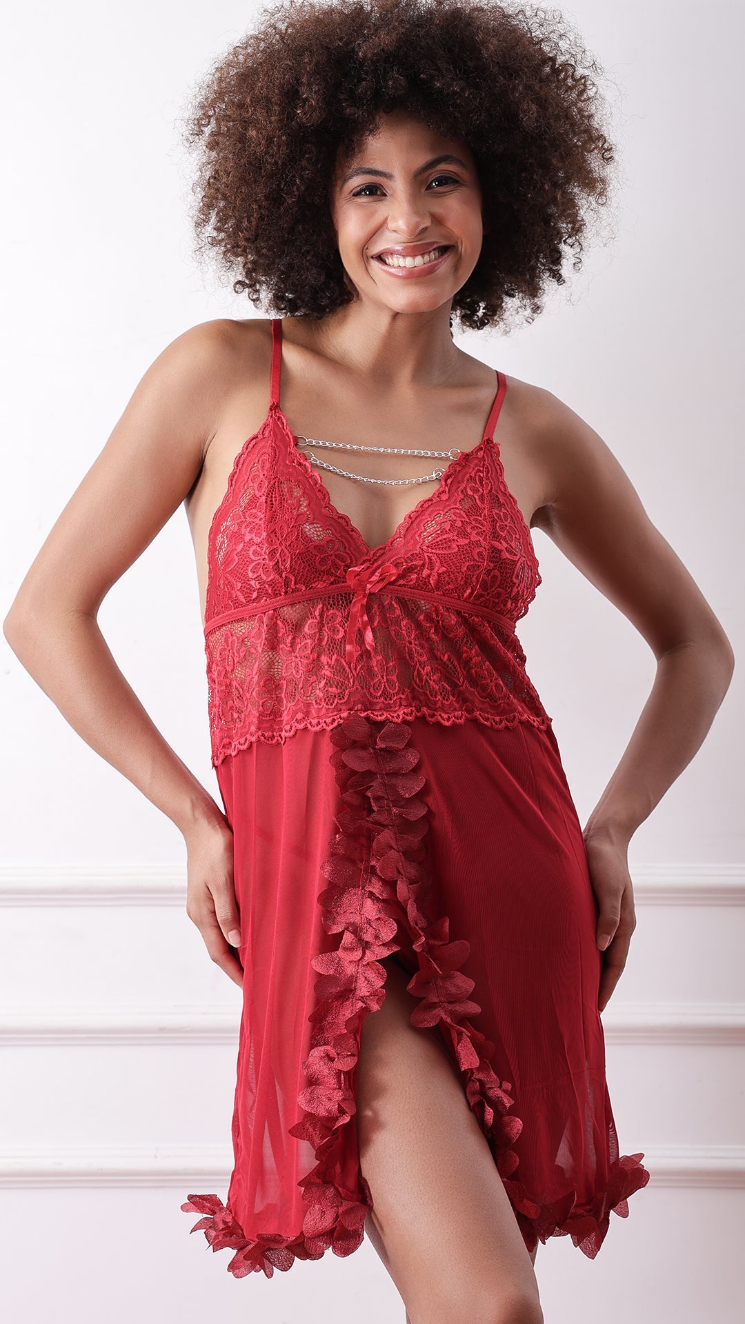 Woman wearing red lace babydoll with body chain and petal hem, front view
