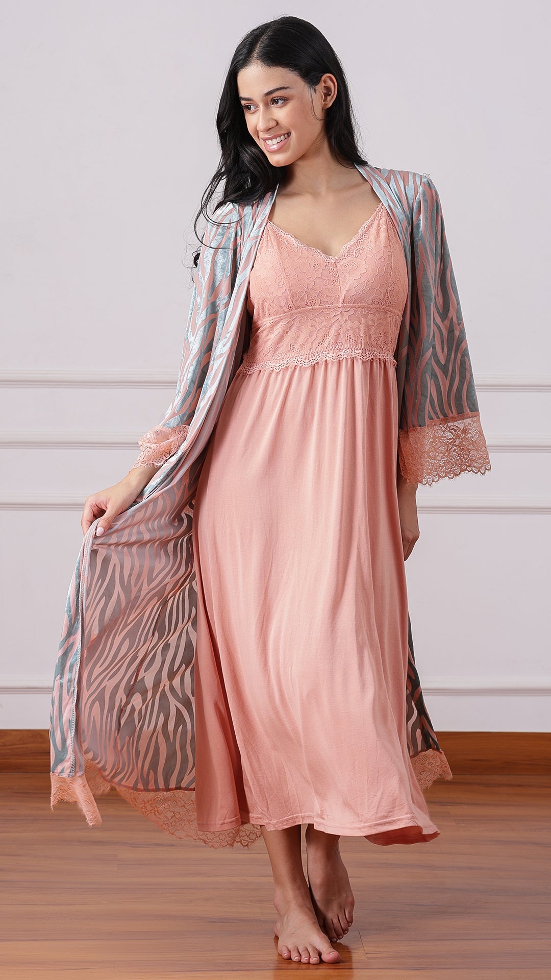 Woman wearing peach lace-bodice nightgown with zebra-print robe