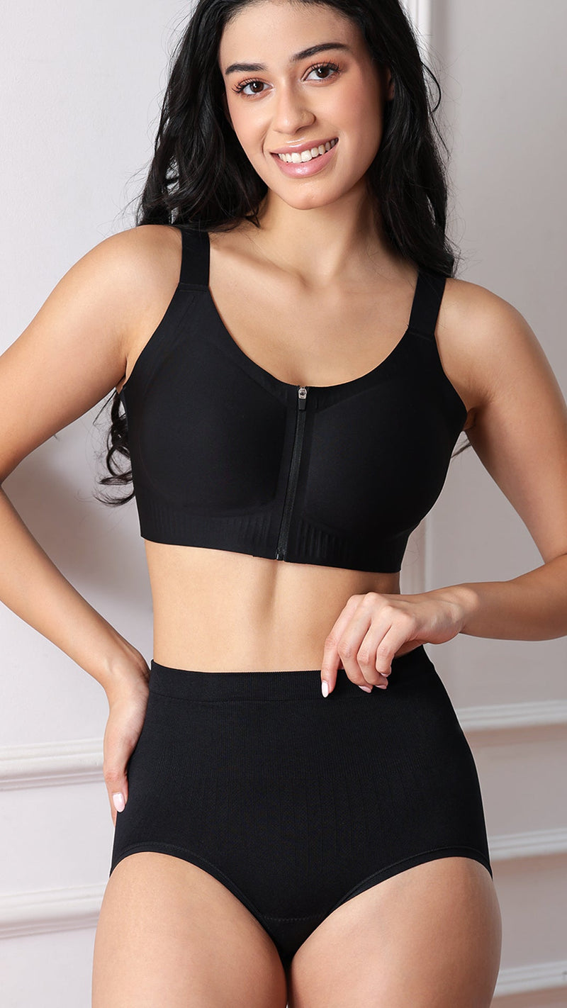 Model wearing black front-zip sports bra and high-waist briefs, front view