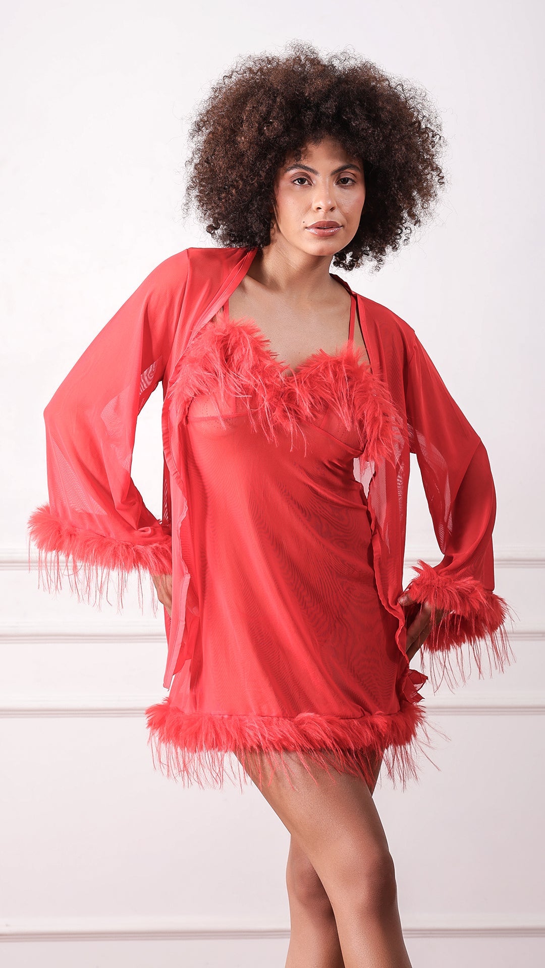 Woman wearing red sheer mesh slip dress with feather trim and robe