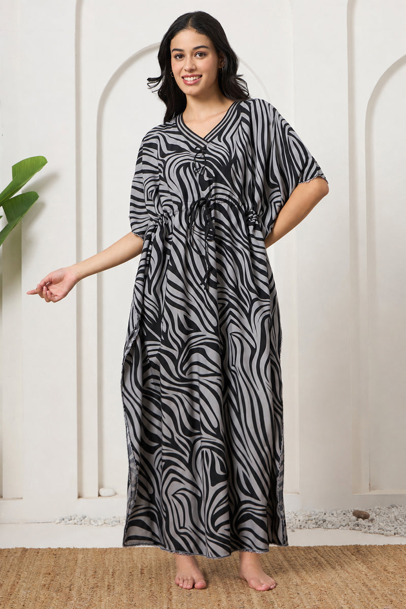 Woman smiling in a black and grey zebra print kaftan
