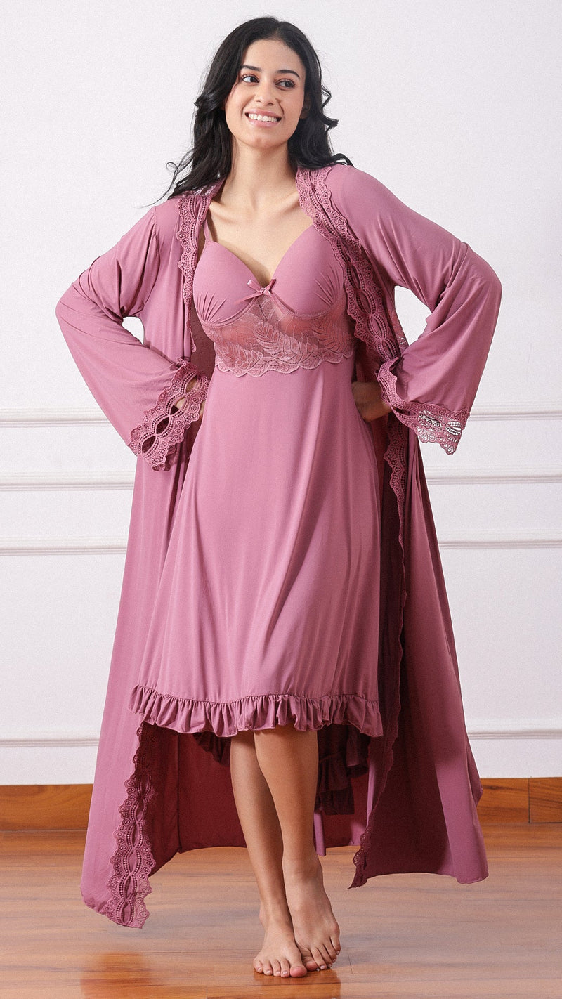 Woman wearing a mauve nightdress with lace bodice and matching robe, hands on hips