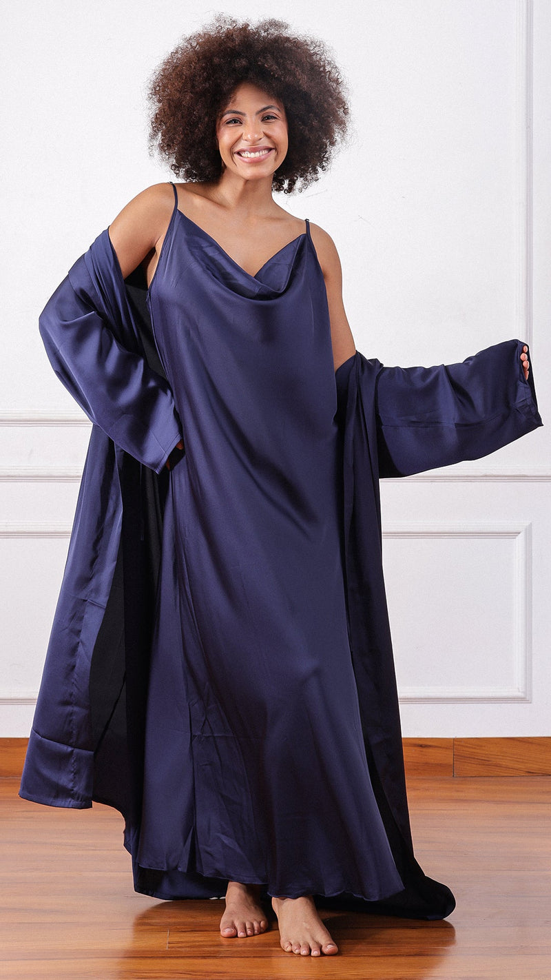 Woman wearing a navy satin cowl-neck slip dress with matching robe