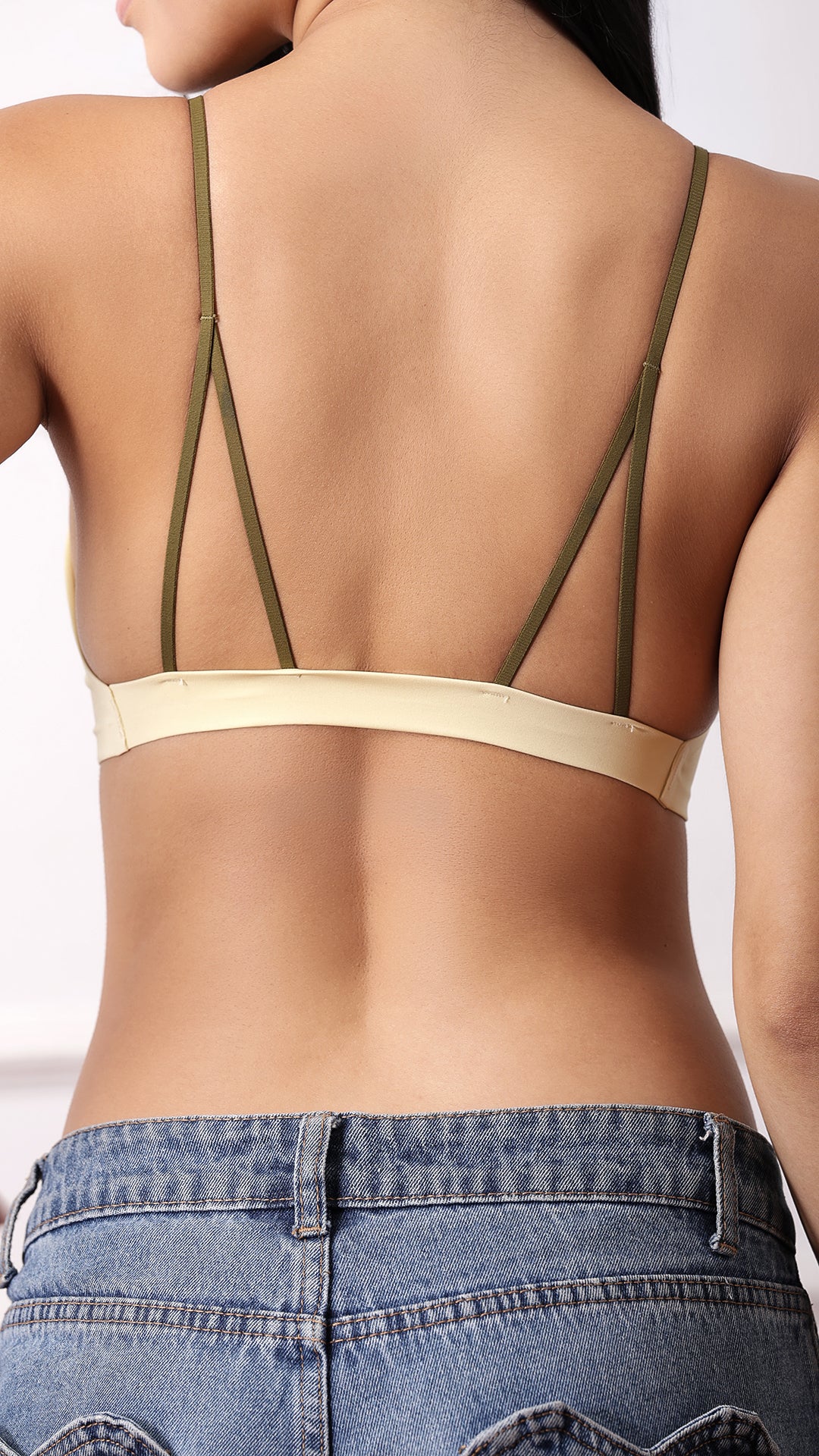 Product shot of beige strappy back bralette on white background