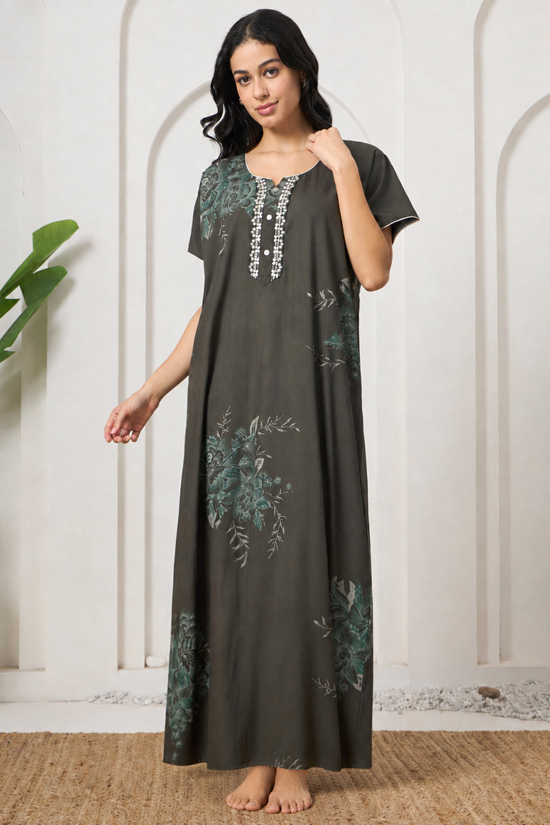 Woman smiling in an olive green floral print nightgown with lace trim neckline