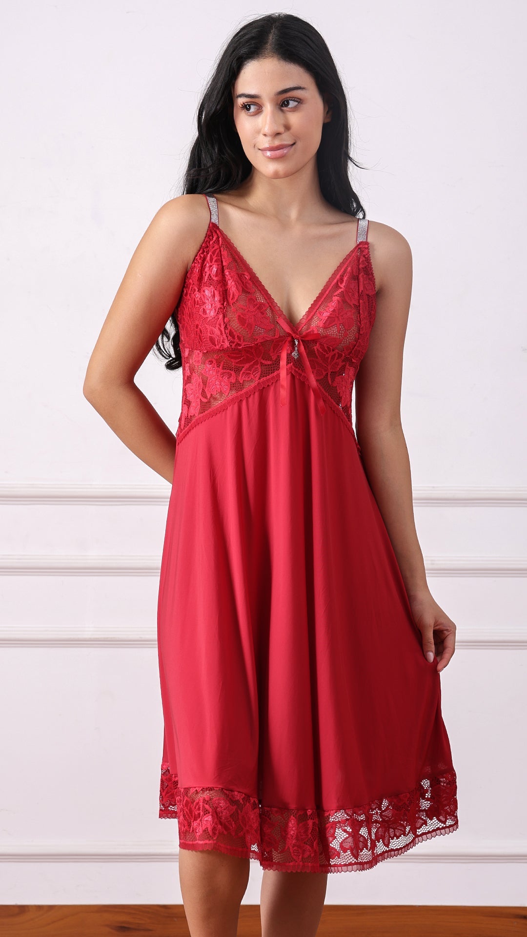 Woman wearing a red satin nightdress with lace bodice and shimmer straps