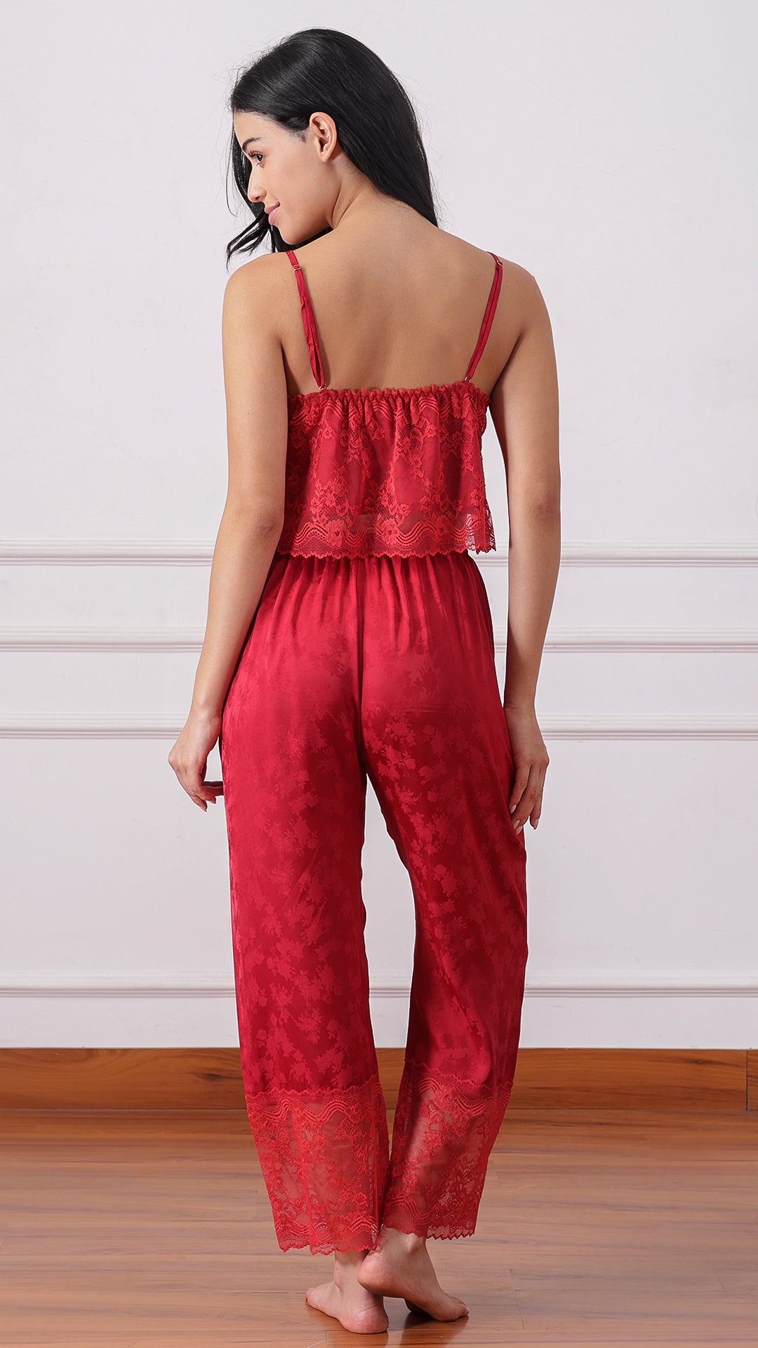Back view of woman wearing a red lace cami and satin pyjama set