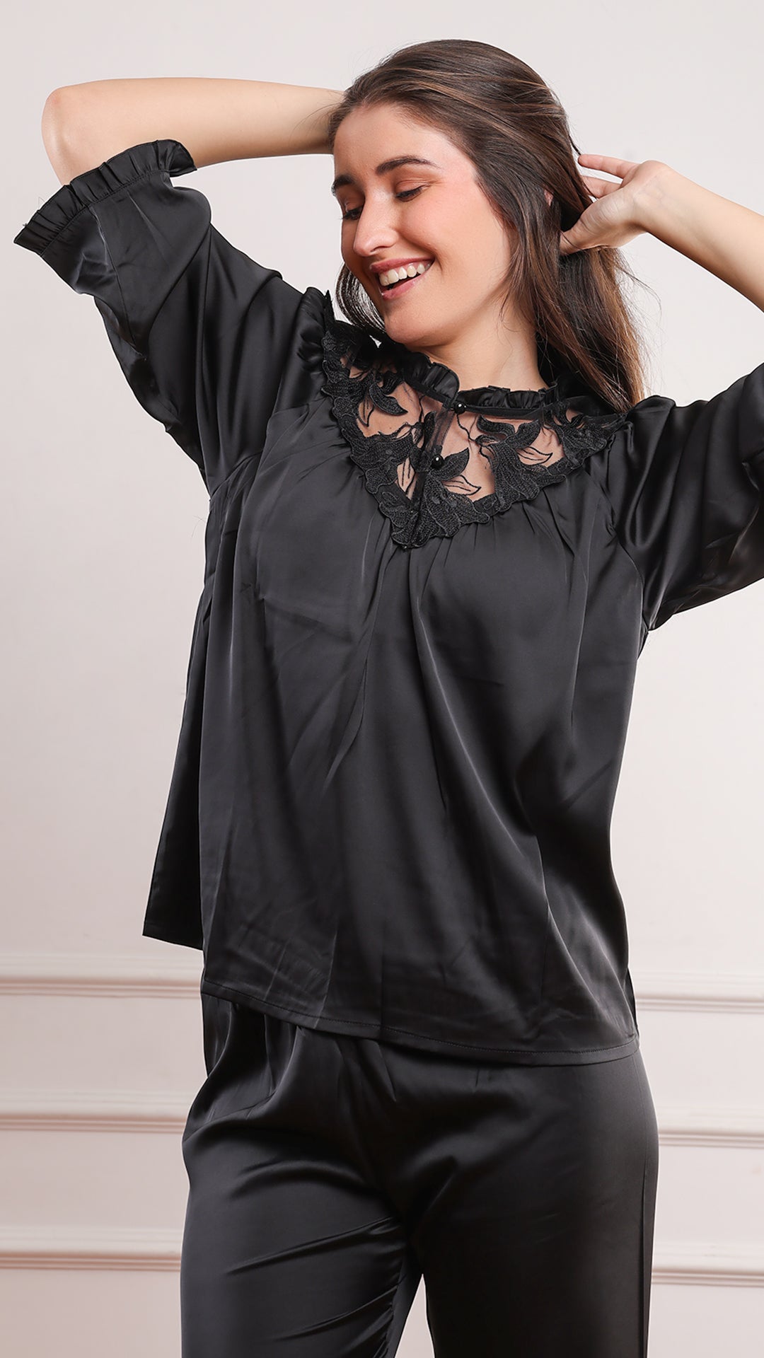 Black satin pajama set with sheer floral lace neckline and relaxed fit