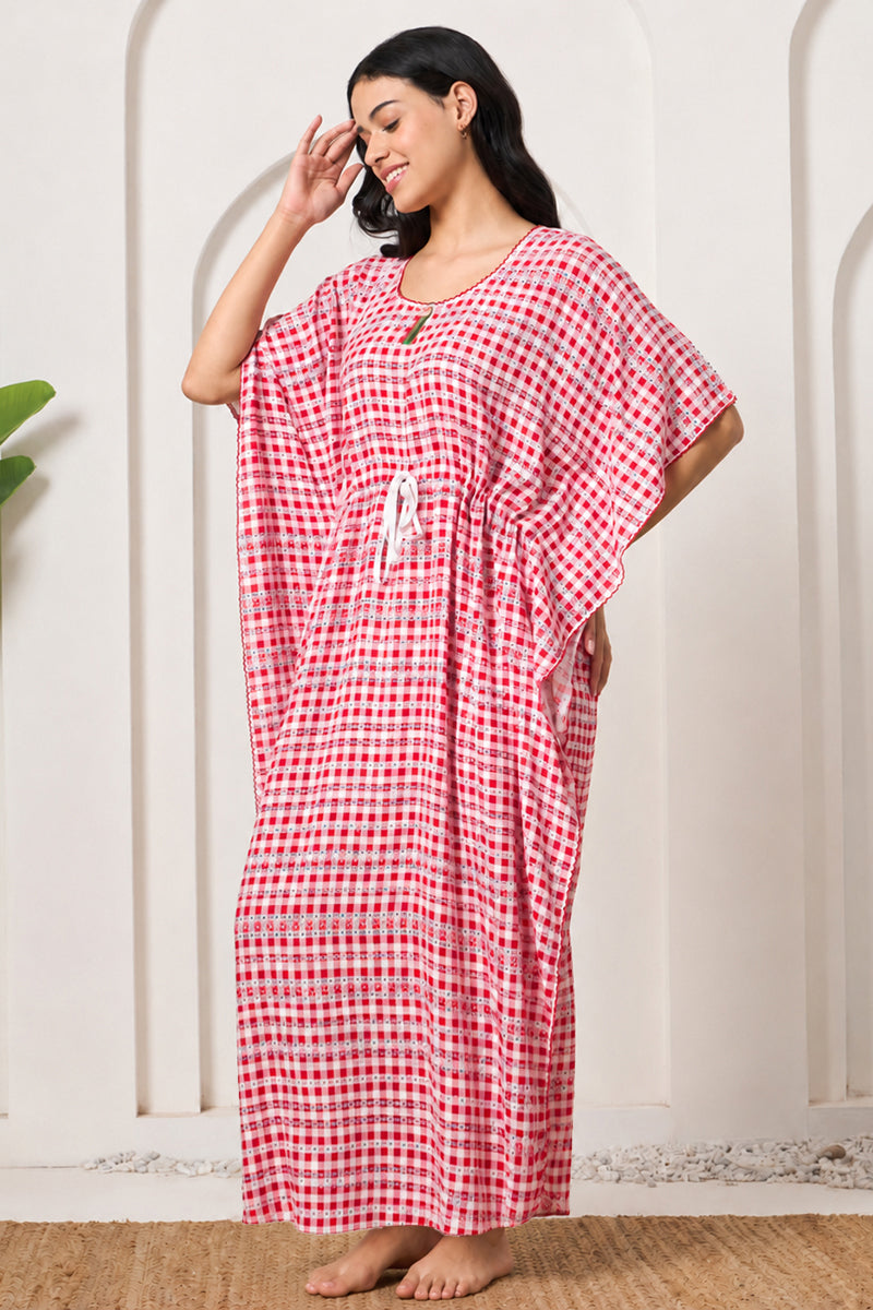 Woman posing sideways in a red gingham kaftan
