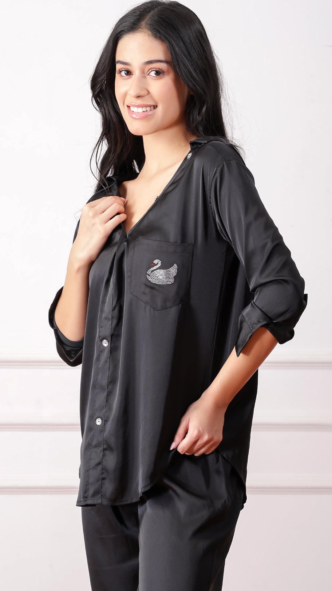 Woman posing in black satin shirt and trouser pyjama set