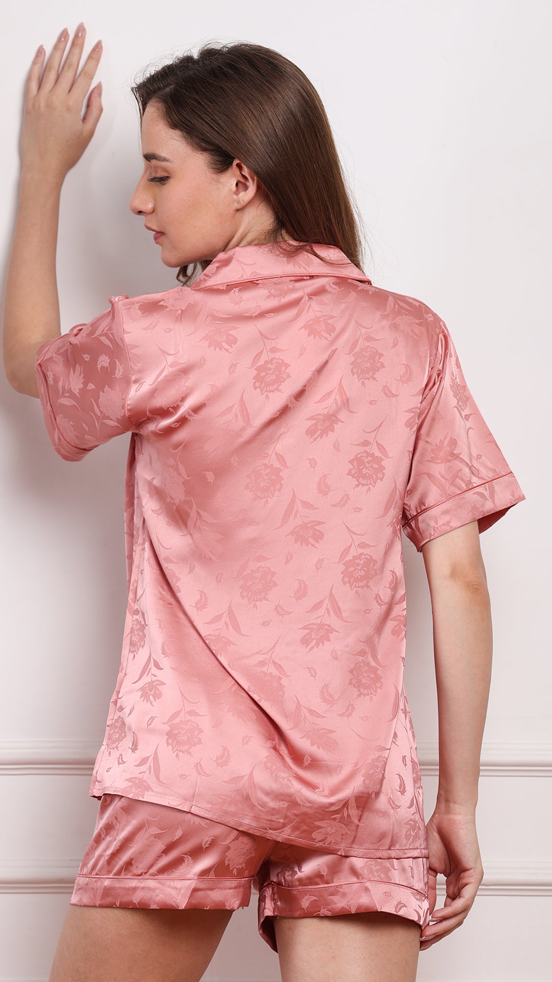 Back view of women's rose pink jacquard satin sleepwear set with floral woven pattern and matching shorts
