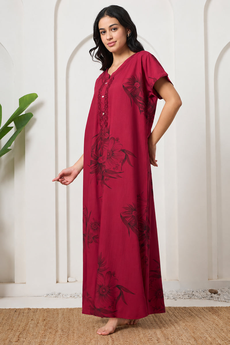Woman standing sideways in a maroon floral nightgown