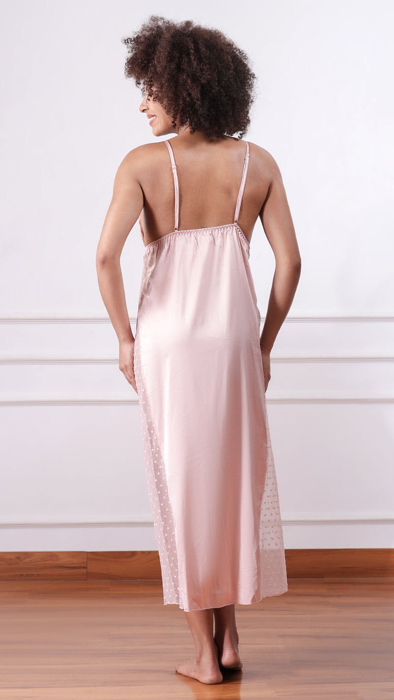 Back view of woman wearing blush pink satin nightdress with adjustable straps