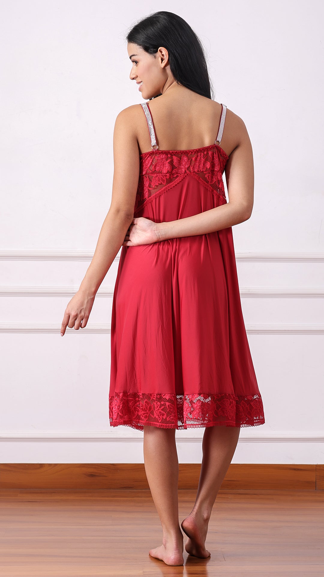 Back view of woman wearing a red satin nightdress with shimmer straps