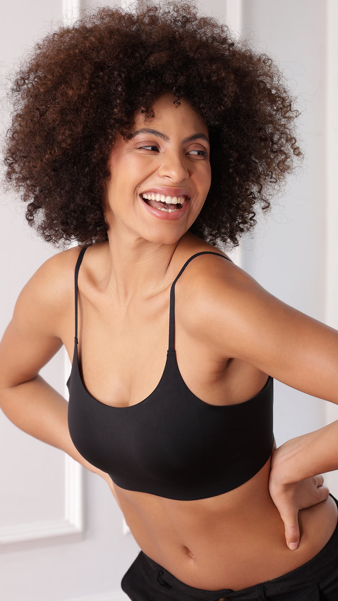Close-up of model wearing black seamless cami bralette, front view