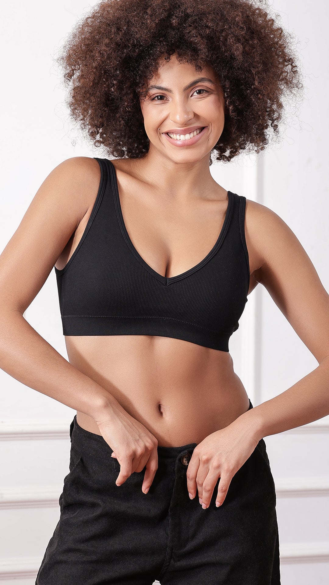 Woman wearing black V-neck ribbed padded bra, front view