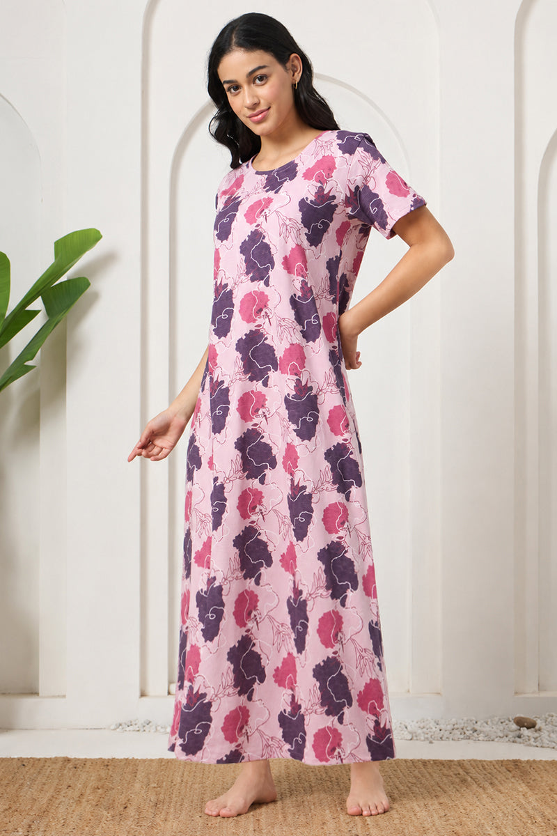 Woman posing in a pink and purple floral print nightdress, hand on hip