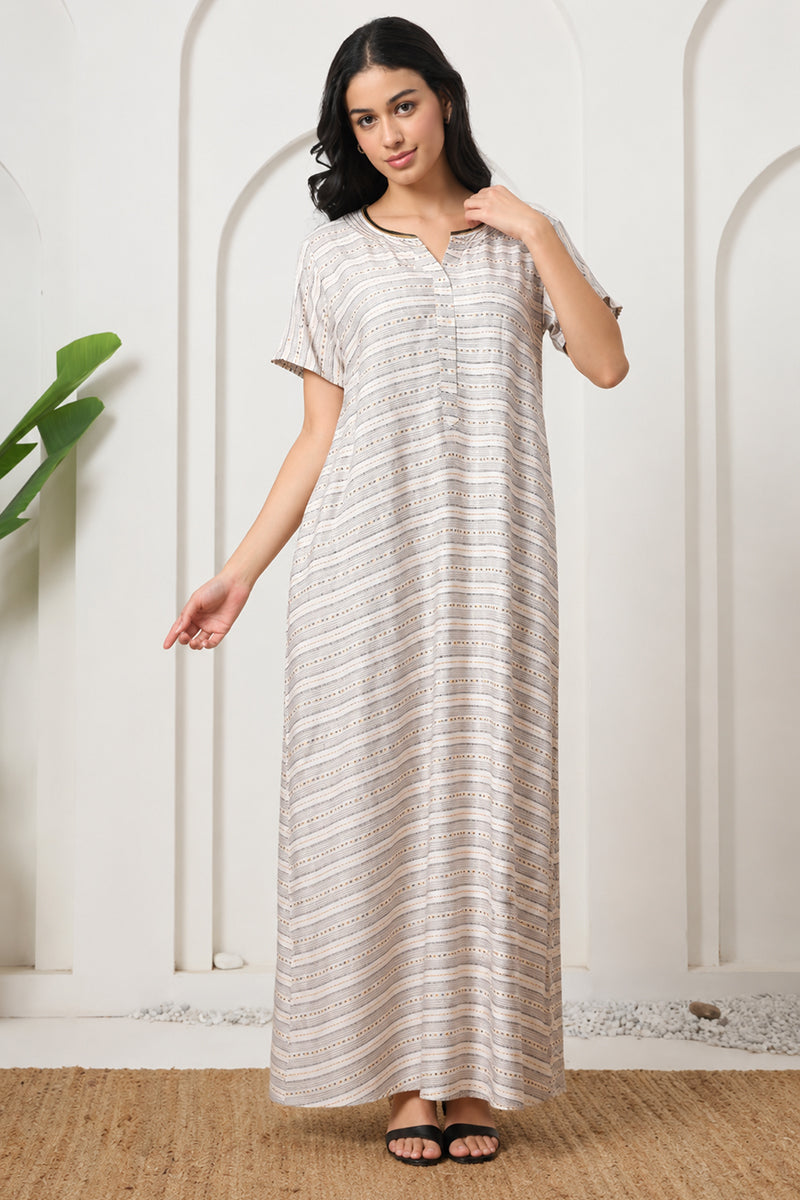 Woman standing in a beige striped print nightgown