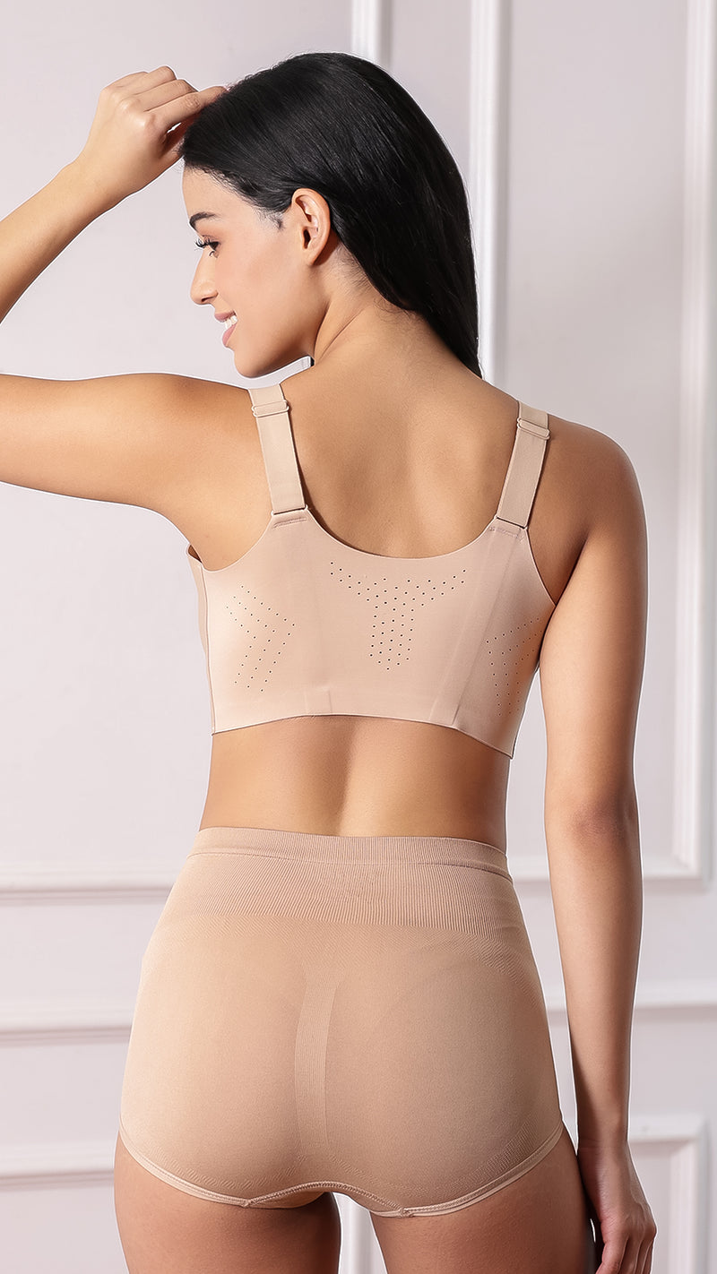Back view of beige sports bra showing wide straps and perforated ventilation