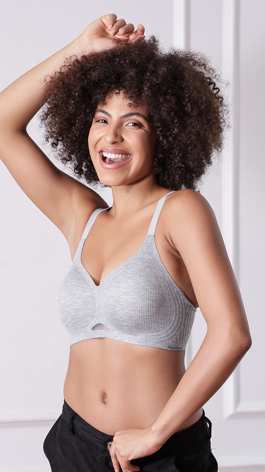 Woman smiling in grey ribbed seamless bra with adjustable straps