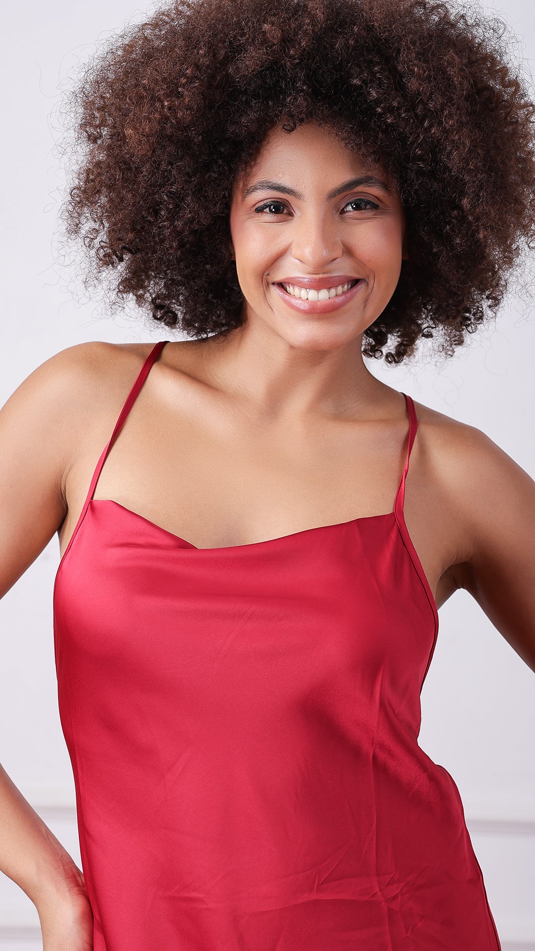 Close-up of woman smiling in maroon satin cowl-neck nightgown