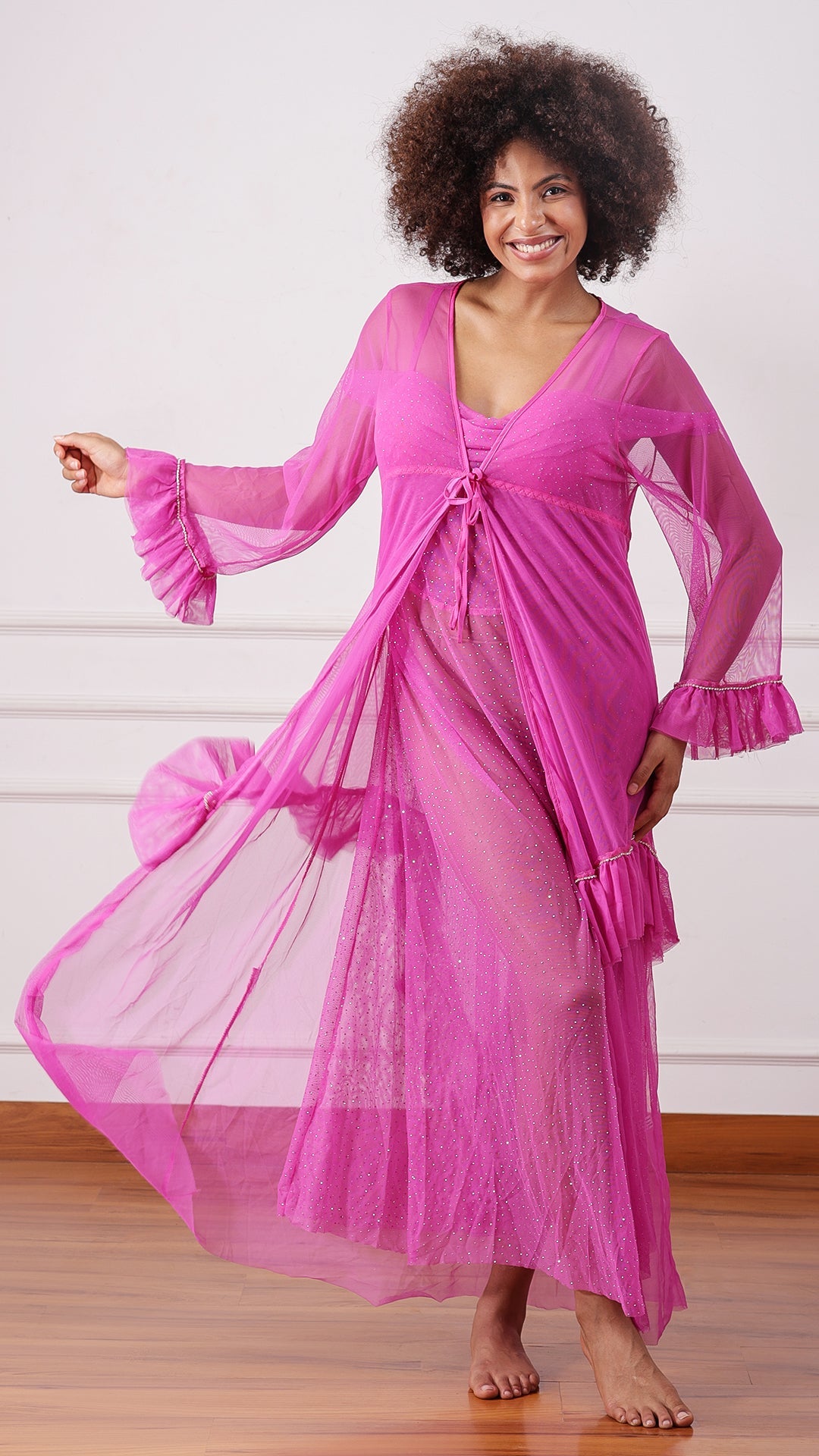 Woman wearing a sheer pink mesh nightdress, hand on hip