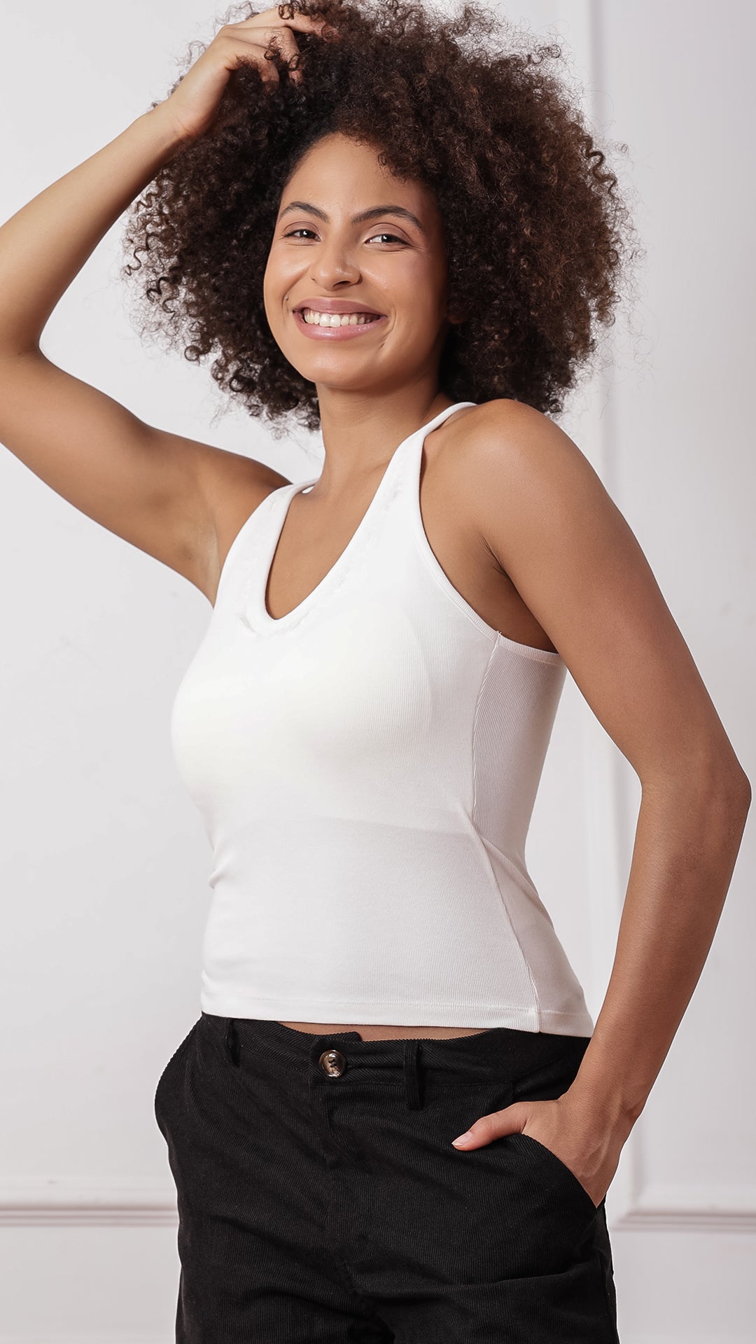 White lace-trim racerback tank top worn with black pants, side view