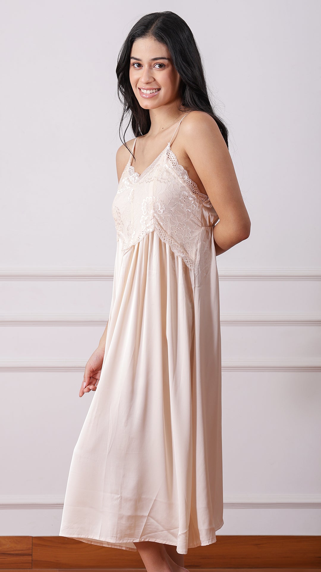 Side view of woman wearing beige satin lace nightgown