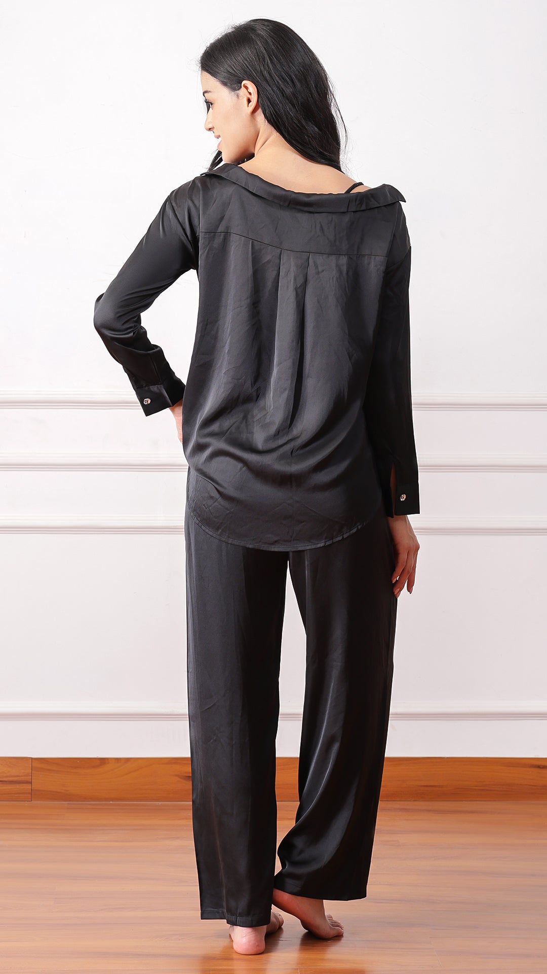 Back view of woman wearing black satin pyjama set