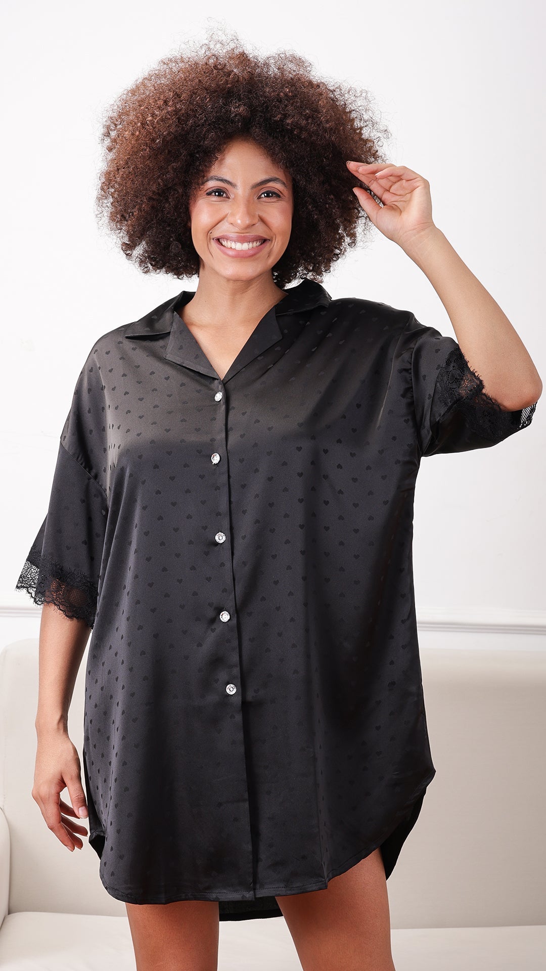 Black satin button-down sleep shirt with lace trim, seated front view