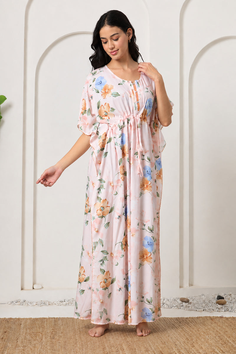 Woman smiling and adjusting the collar of her pink floral kaftan