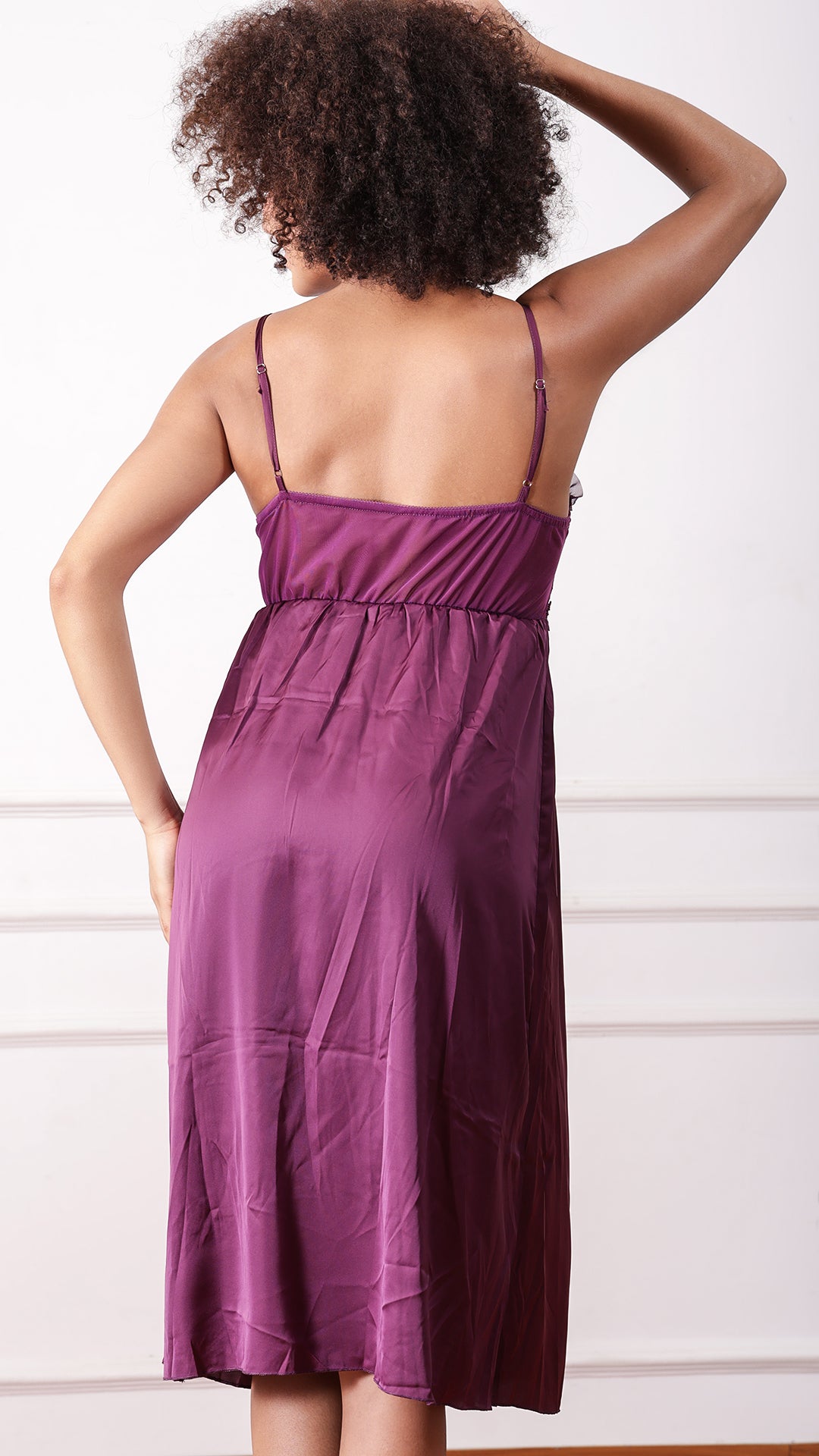 Back view of woman wearing purple satin nightgown