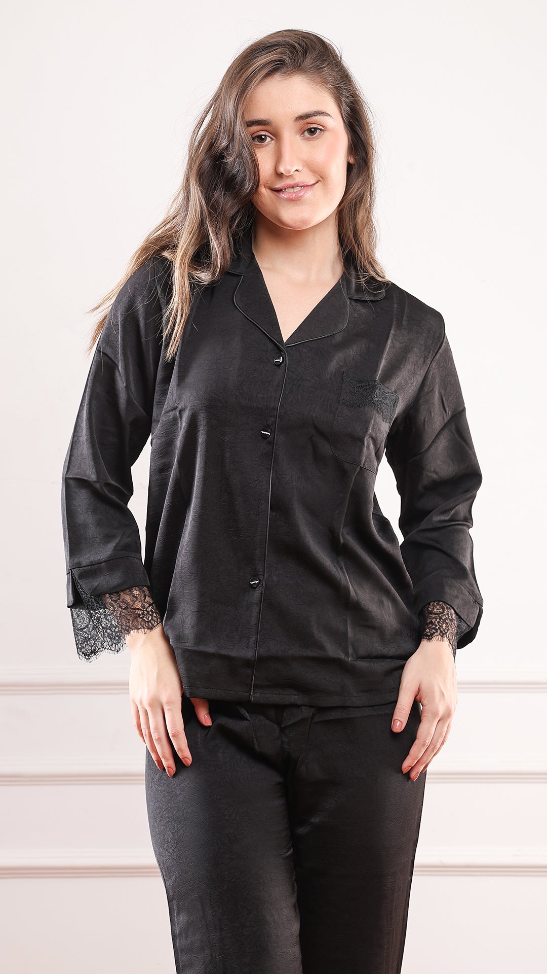 Woman wearing black silk satin pajama shirt with lace trim cuffs and notched collar, front close-up view