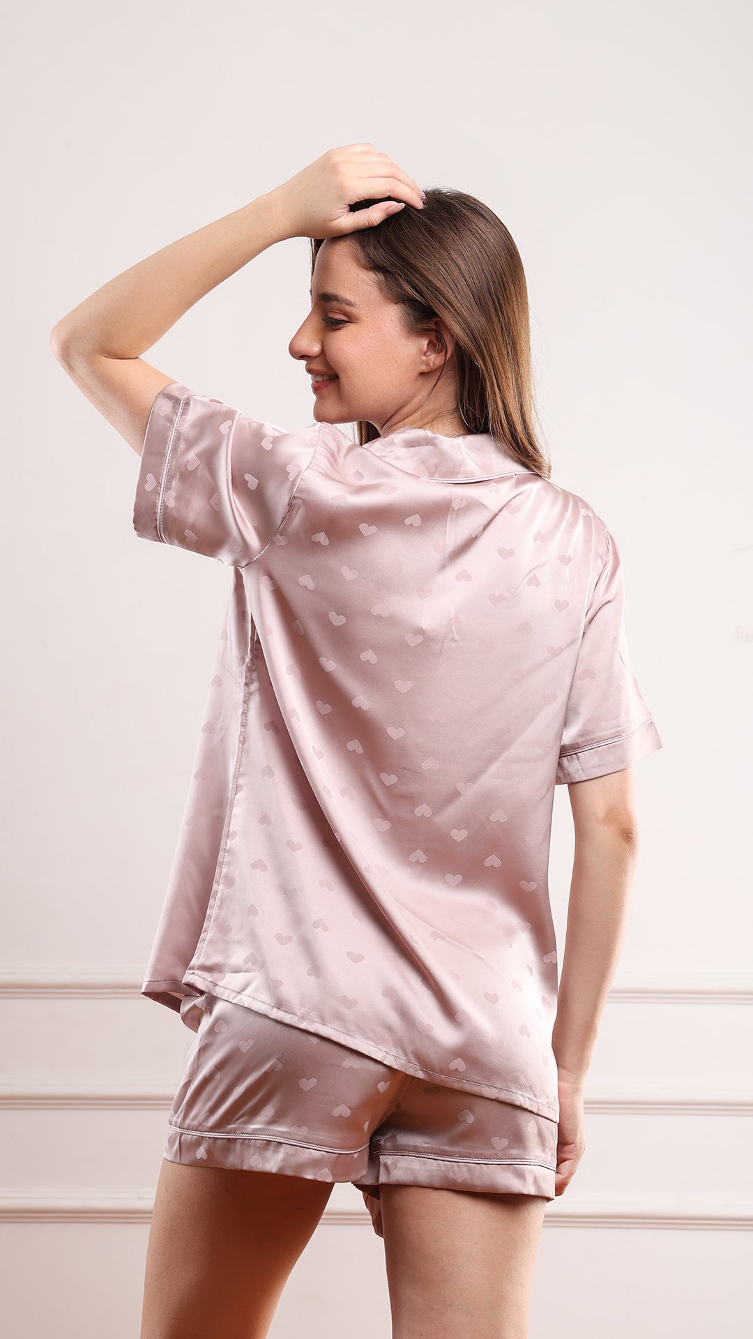Back view of dusty pink heart jacquard satin pajama shirt and shorts set showing all-over heart print
