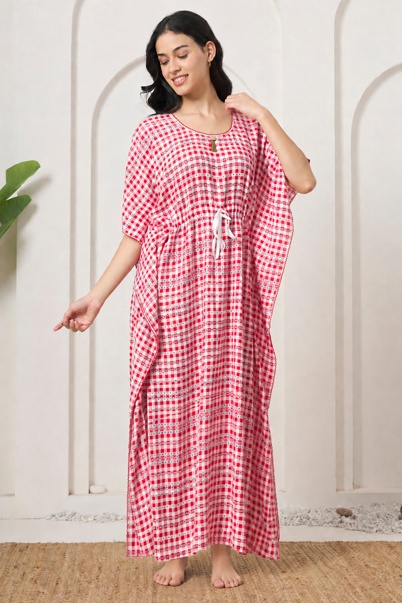 Woman standing and adjusting the collar of her red check kaftan