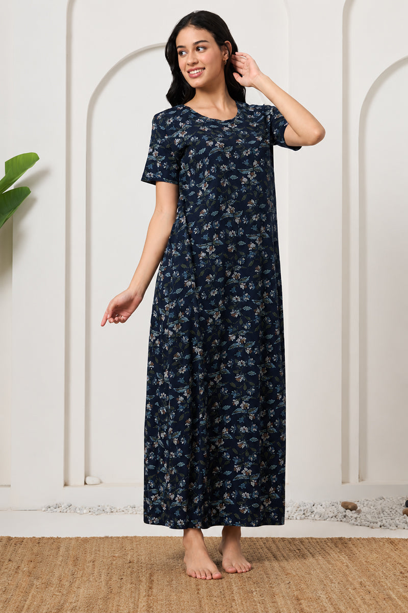 Woman smiling in a navy floral print nightdress, looking to the side