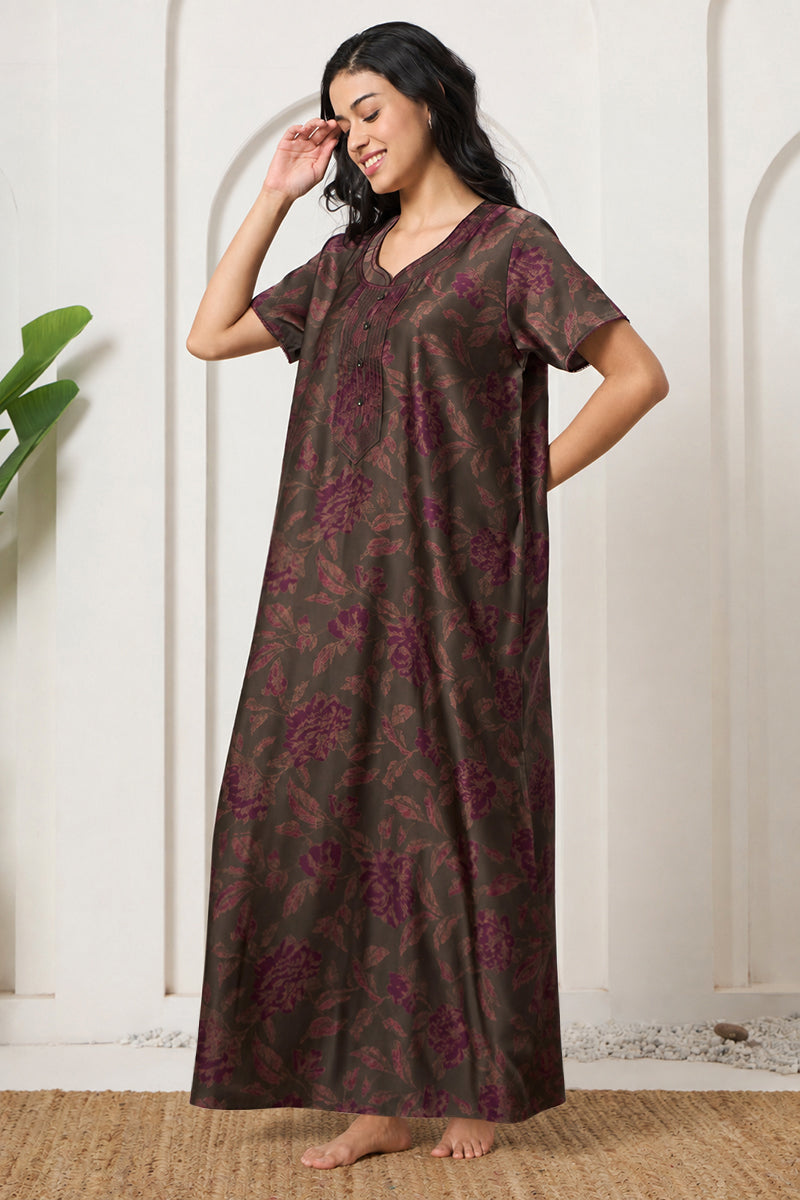 Woman smiling with hand in hair, wearing an olive floral print nightgown